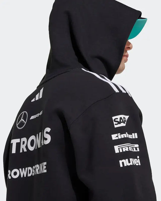Person wearing a black hoodie with various logos on the back against a white background