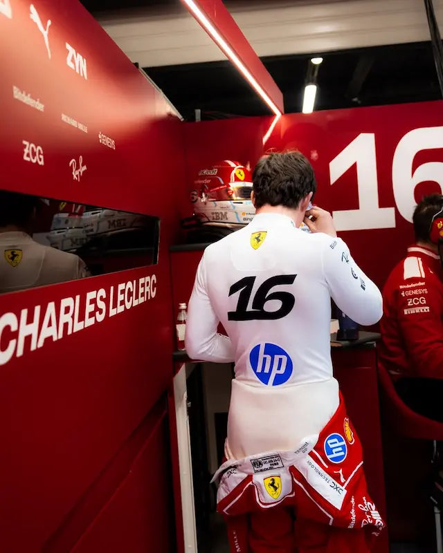 Person in a Formula 1 pit lane with branding and equipment visible