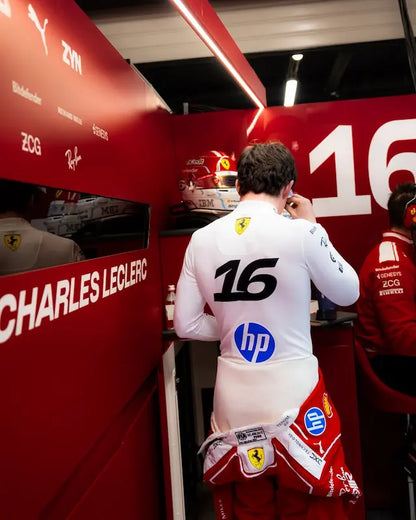 Person in a Formula 1 pit lane with branding and equipment visible