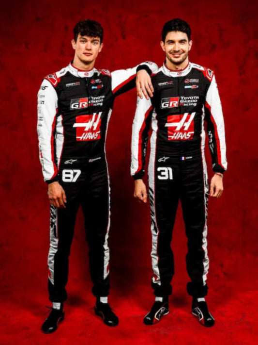 Both TGR Haas F1 replica suits displayed side by side, showcasing driver pair.