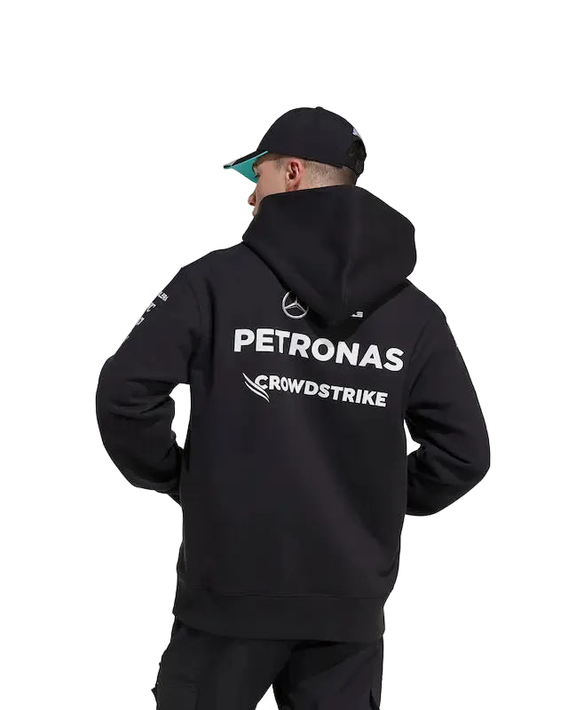 Person wearing a black hoodie with Petronas and CrowdStrike logos on the back against a white background