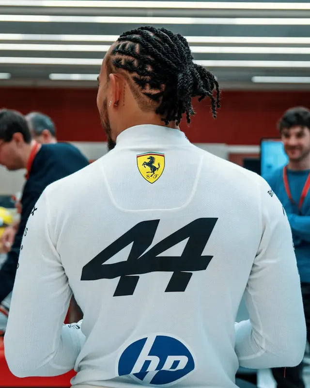 Lewis wearing a white racing suit with Ferrari and HP logos