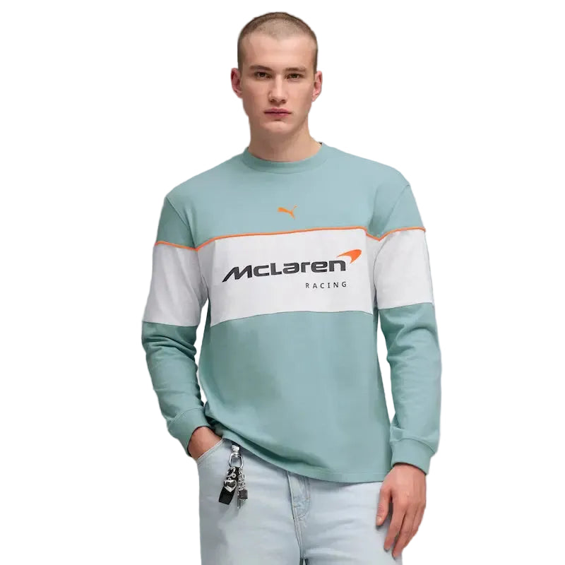 Person wearing a light blue sweatshirt with McLaren Racing logo on a gray background