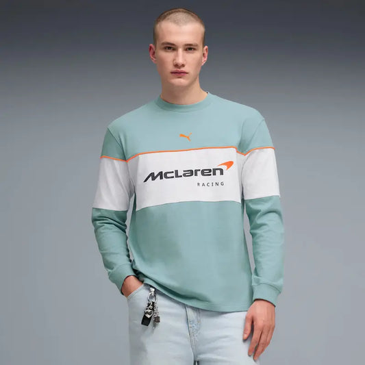 Person wearing a light blue sweatshirt with McLaren Racing logo on a gray background