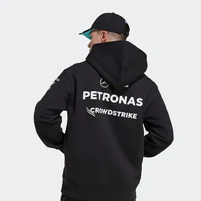 Person wearing a black hoodie with Petronas and CrowdStrike logos on the back, against a white background