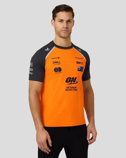 Man wearing an orange and black sports jersey with various brand logos on a gray background