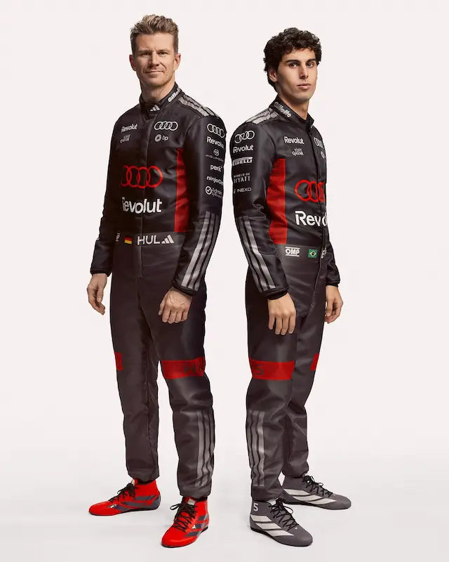 Two individuals wearing Audi racing suits on a white background