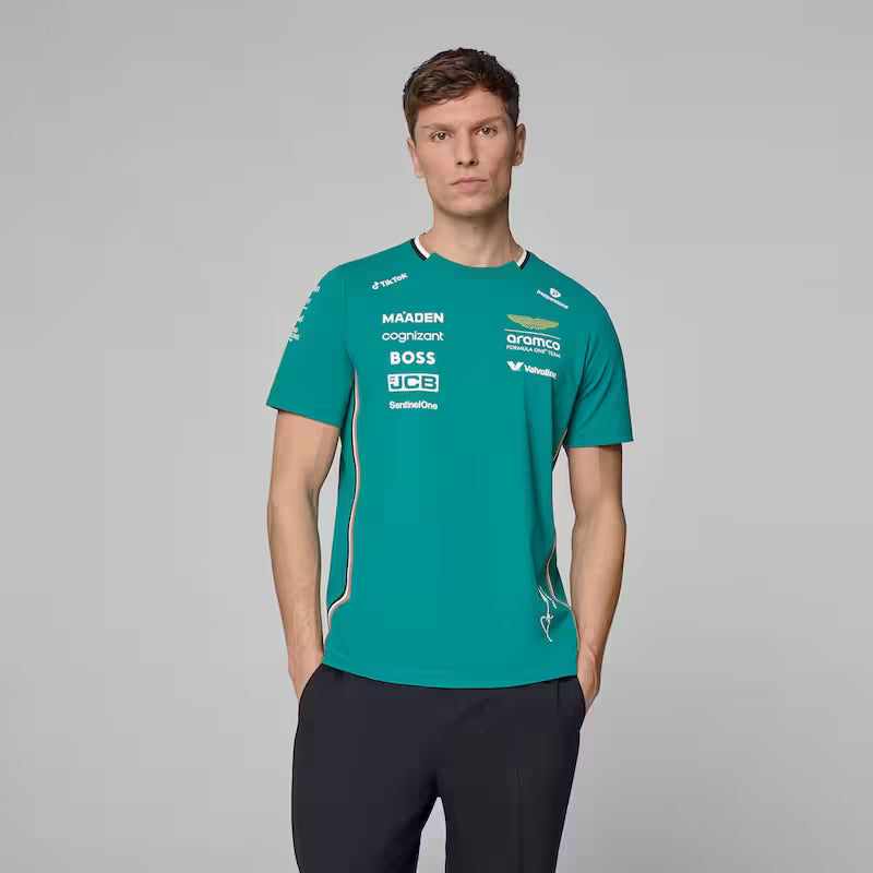 Man wearing a teal sports jersey with various sponsor logos on a gray background