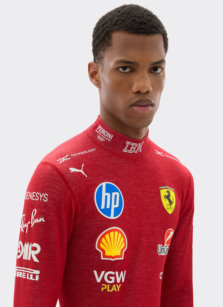 Person wearing a red racing suit with various sponsor logos on a white background